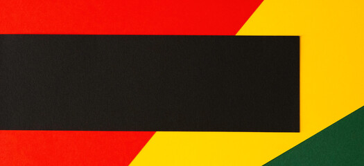 Abstract geometric background. Black horizontal stripe with copy space on red, yellow, green color background. Black History Month background