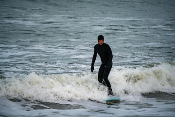 Surfer catching waves in cold water in winter, cold hawaii, norre vorupor, Klitmoller and...