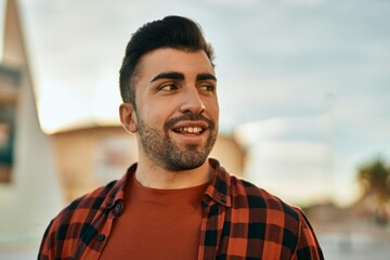 Fototapeta premium Young hispanic man smiling happy standing at the city.