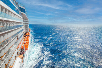 Ocean view from a cruise ship deck on a bright day with blue skies and clouds in the Pacific ocean with copy space