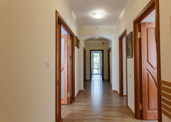 long corridor in a house with many open wooden doors. corridor in a hostel or hotel with many open...