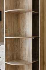 stylish open brown wooden wardrobe with shelves close up on background with copy space for text