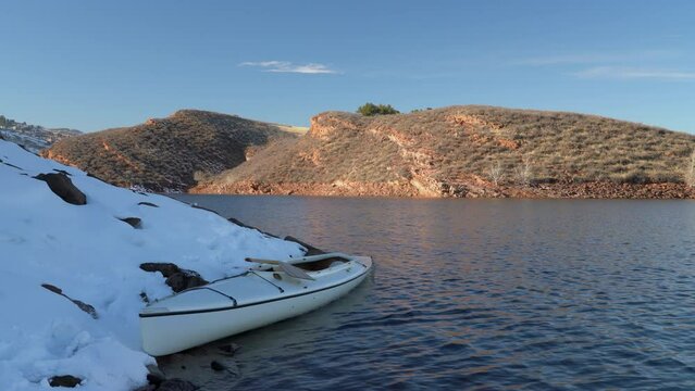 winter paddling at sunset on Horsetooth Reservoir in Colorado, decked expedition canoe wobbling on small waves