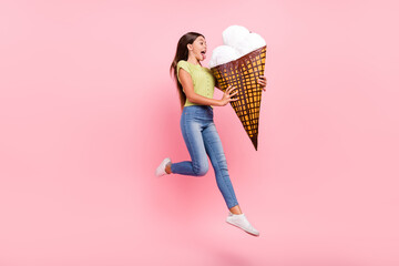 Profile photo of crazy hungry lady hold big cone ice cream jump lick wear green top jeans isolated...