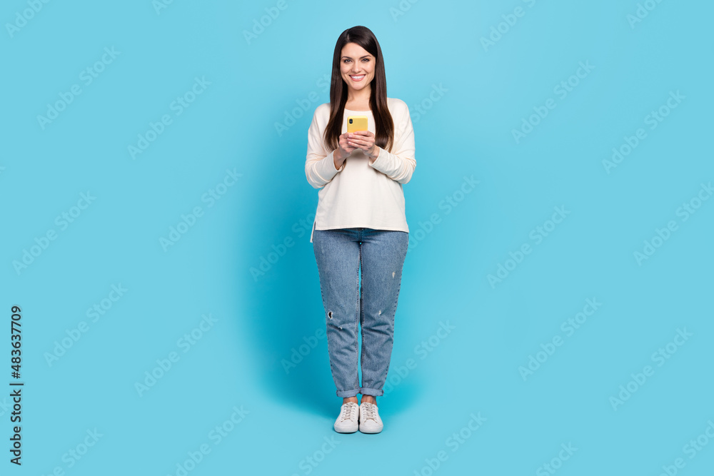 Sticker Full length photo of young cheerful girl use mobile share repost app download app isolated over blue color background