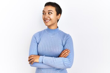 Young hispanic woman with short hair standing over isolated background smiling looking to the side and staring away thinking.