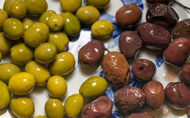 Organic olives in green and black on the breakfast plate.