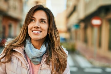 Young hispanic woman smiling happy standing at the city.