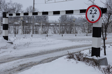 road sign and barrier limiting the height of incoming vehicles