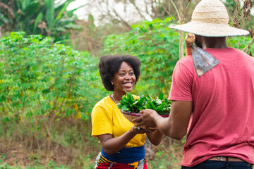 woman carrying a basket of vegetable from a man