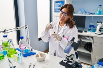 Young latin woman wearing scientist uniform working at laboratory