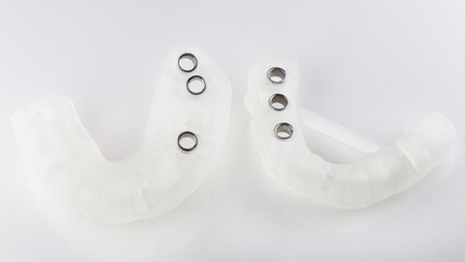 two surgical template for the installation of six dental implants, top view on a white background