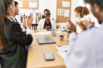 Group of business workers smiling and clapping to partner at the office.
