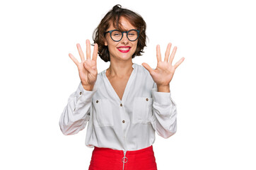 Young hispanic woman wearing business style and glasses showing and pointing up with fingers number...