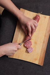 Naklejka premium Salami sausage cut into pieces on a cutting board