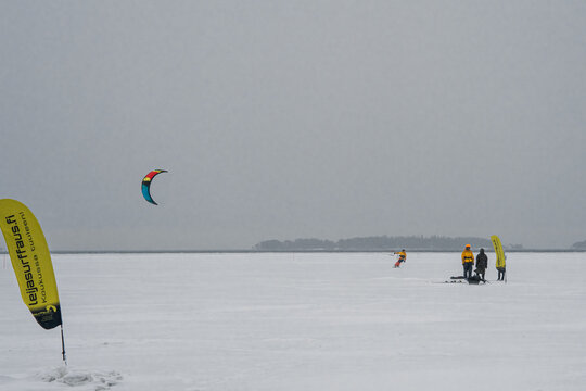 Finland. Espoo. January 29, 2022 . On the ice in the sea a group of kite surfers, they are skiing, bad weather, strong wind and blizzard