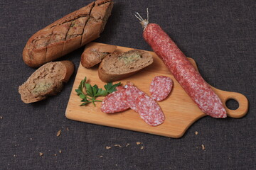 Dried sausage on the table. Raw smoked sausage on a cutting board.