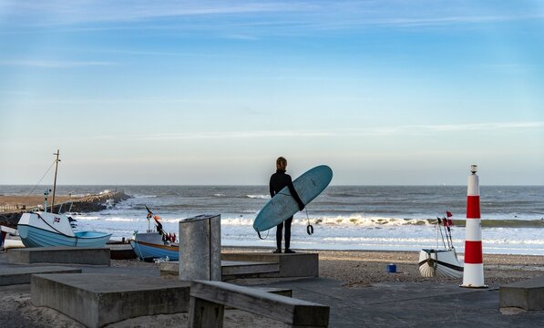Surfer wait to catching waves in cold water in winter, cold hawaii, norre vorupor, Klitmoller and Hanstholm, denmark