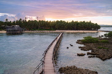 Obraz premium Beautiful landscape. Sunset on the seashore. Wooden bridge on Cloud Nine beach, Siargao Island Philippines.