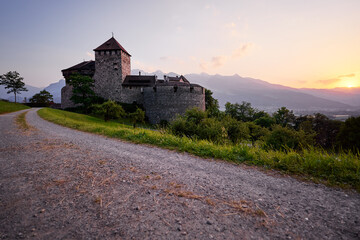 Vaduz Castle, the official residence of the Prince of Liechtenstein, with Alps mountains in background on sunset.