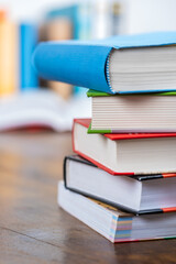 Close-up  stack of books on desk with blurred soft library background