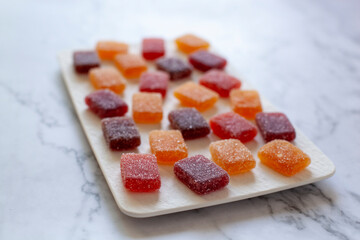 Fruit paste on a square plate on marble background, selective focus