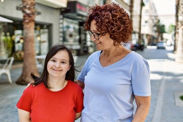 Fototapeta premium Mature mother and down syndorme daughter smiling happy and friendly outdoors