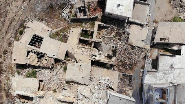 Broken roofs and collapsed walls of buildings, top down aerial shot. Small houses at old flooded and dilapidated village at Crete island