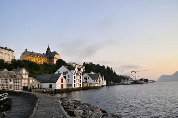 Alesund, Norway - 05 July 2011: Old colorful houses on the waterfront in Alesund, Norway in the evening at sunset.