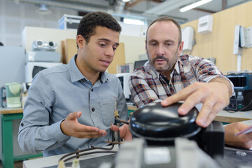 man and apprentice watching printing machine