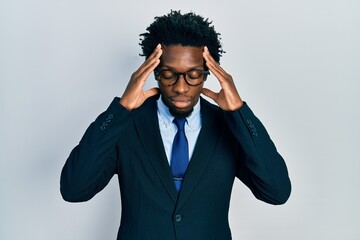 Young african american man wearing business suit suffering from headache desperate and stressed because pain and migraine. hands on head.