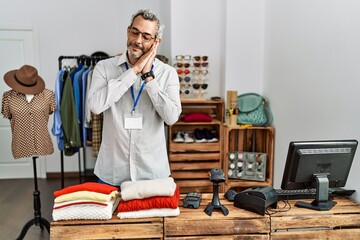 Fototapeta premium Middle age hispanic man working as manager at retail boutique sleeping tired dreaming and posing with hands together while smiling with closed eyes.