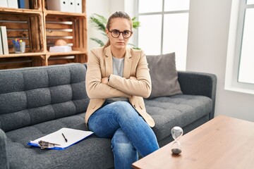 Obraz premium Young woman working at consultation office skeptic and nervous, disapproving expression on face with crossed arms. negative person.