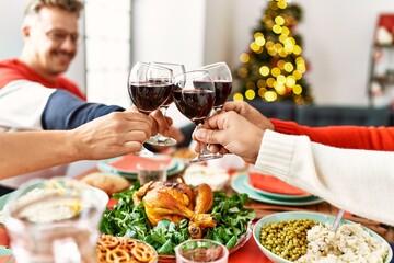 Group of middle age people smiling happy having christmas dinner toasting with wine at home.