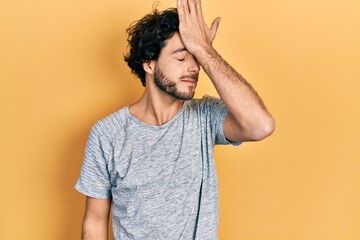 Handsome hispanic man wearing casual grey t shirt surprised with hand on head for mistake, remember error. forgot, bad memory concept. - obrazy, fototapety, plakaty