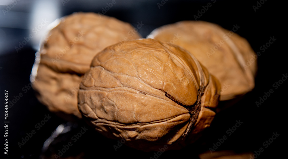 Sticker Three walnuts on dark background