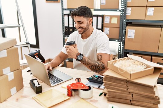 Young hispanic man working at small business ecommerce with laptop smiling with a happy and cool smile on face. showing teeth.