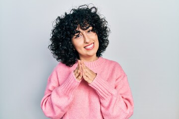 Young middle east woman wearing casual clothes hands together and fingers crossed smiling relaxed and cheerful. success and optimistic