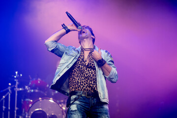 Rock singer singing with group and drums behind