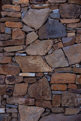 a fragment of a city wall made of natural stone of various colors and textures