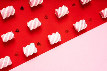 Pattern of small marshmallows on a red background and a pink empty part for copy space
