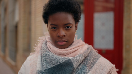 Young african american woman with serious expression standing at street