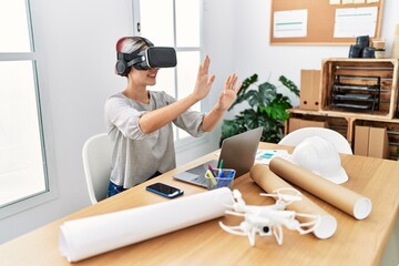 Young caucasian architect woman working using virtual reality glasses at the office.