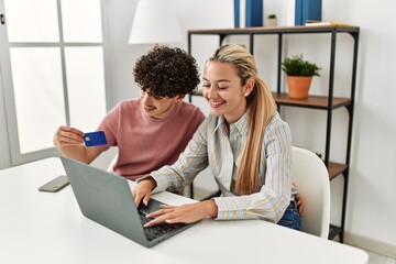 Young couple buying using laptop and credit card at home.