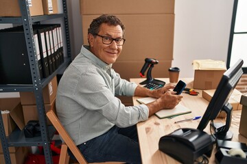 Middle age man ecommerce business worker using smartphone at office
