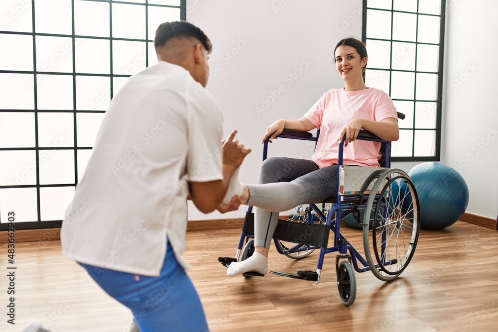 Wall mural Young disabled woman having mobility exercise sitting on wheelchair at the clinic.