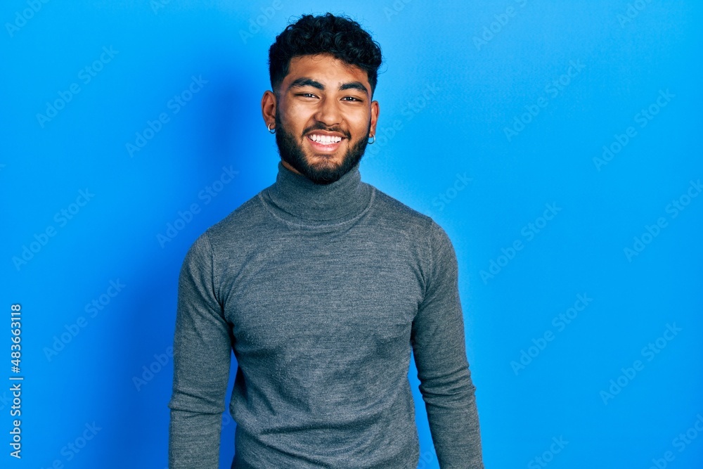 Poster arab man with beard wearing turtleneck sweater winking looking at the camera with sexy expression, c