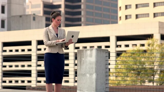 Businesswoman using laptop outdoors
