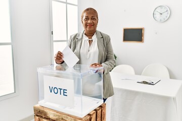 Senior african american woman smiling confident voting at charity center