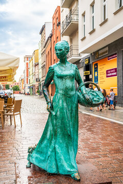 Torun, Poland - August 11, 2021. Statue of woman baker on Male Garbary street - Ginger bread woman baker monument - Pomnik Piernikarki Torunskiej